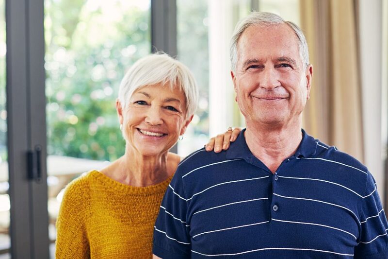Ein glückliches älteres Ehepaar lächelt in die Kamera